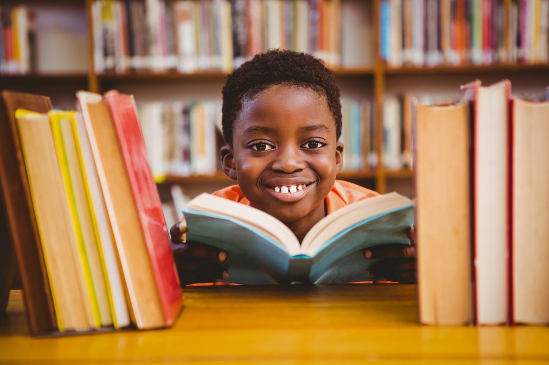 Un jeune garçon souriant dans une bibliothèque